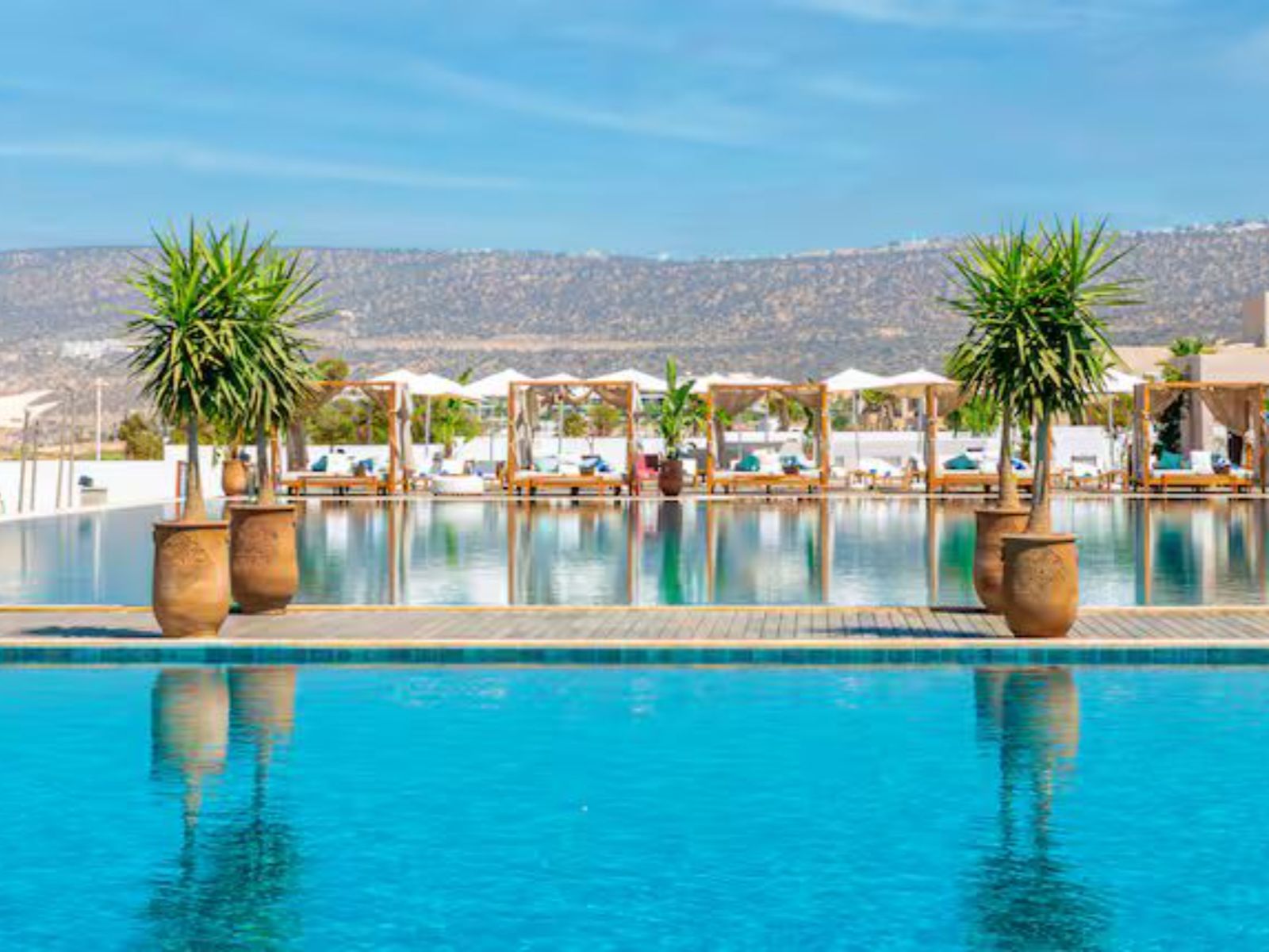 Rondreis Marokko, Taghazout Bay, Hilton Bay Beach Resort & Spa, zwembad met ligstoelen en cabanas